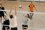 Adults playing volleyball in a gym